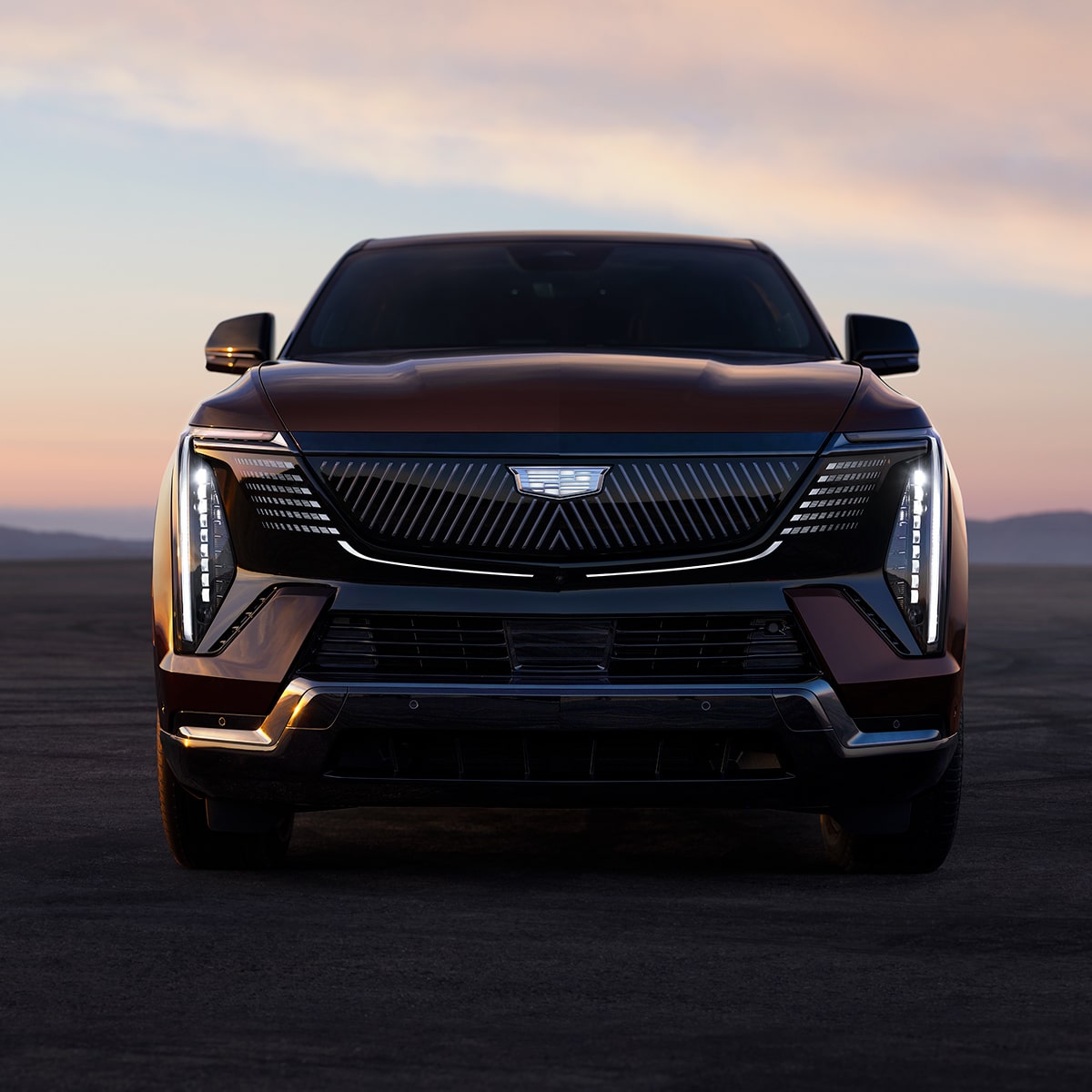 Low Front View of the Cadillac LYRIQ Parked in the Dessert During a Sunset