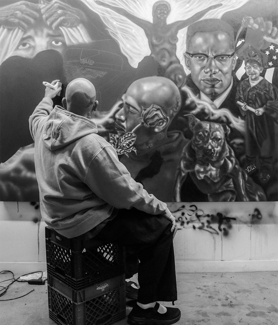 Oakland Artist Esteban Samayoa Sitting and Painting a Black and White Painting Called "All in the Family"