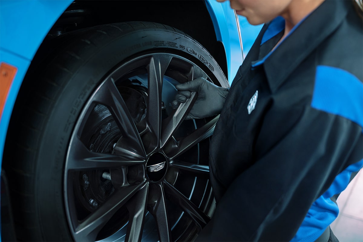 Cadillac Technician Installing a New Wheel on a Vehicle