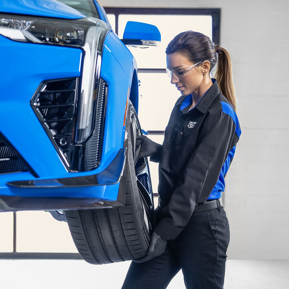 Cadillac Technician Installing a New Tire on a Vehicle