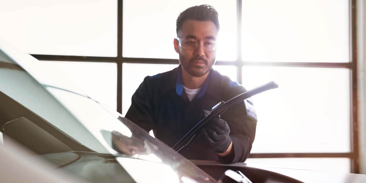 Cadillac Technician Installing New Windshield Wiper Blades on a Vehicle