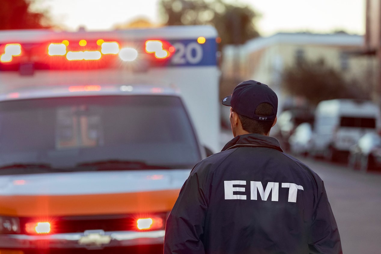 Primer plano de un trabajador de emergencias médicas frente a una ambulancia en la calle