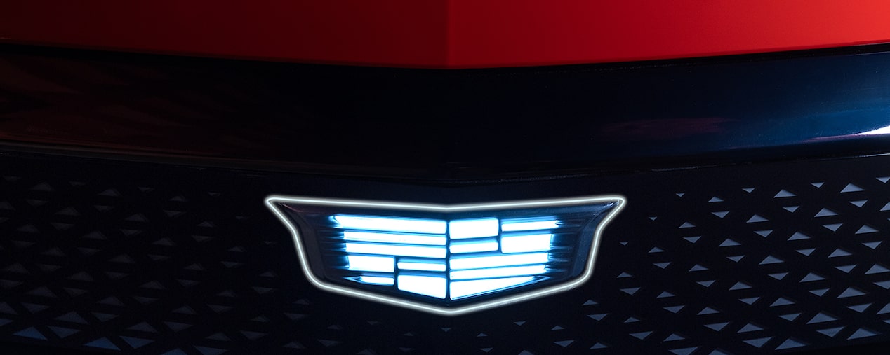 Close-up of a Cadillac Emblem Glowing on the Front Grille of a Vehicle