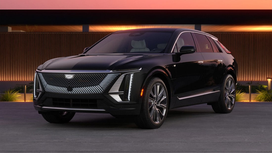 A Cadillac Lyriq Electric Vehicle Parked In Front of a Home at Dusk