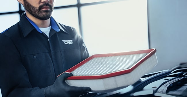 Cadillac Technician Inspecting an Engine Air Filter