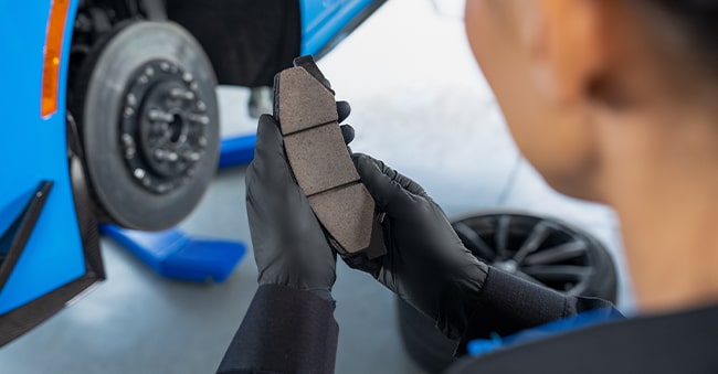 Cadillac Technician Inspecting a Brake Pad