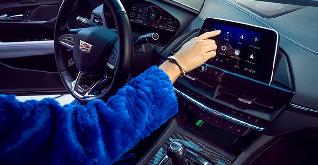 Cadillac Driver Using Infotainment System in Their Vehicle