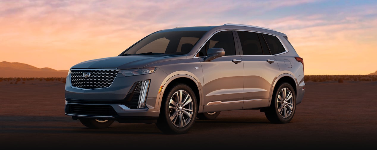 Front Driver's Side View of a Cadillac XT6 Parked in the Desert During a Sunset