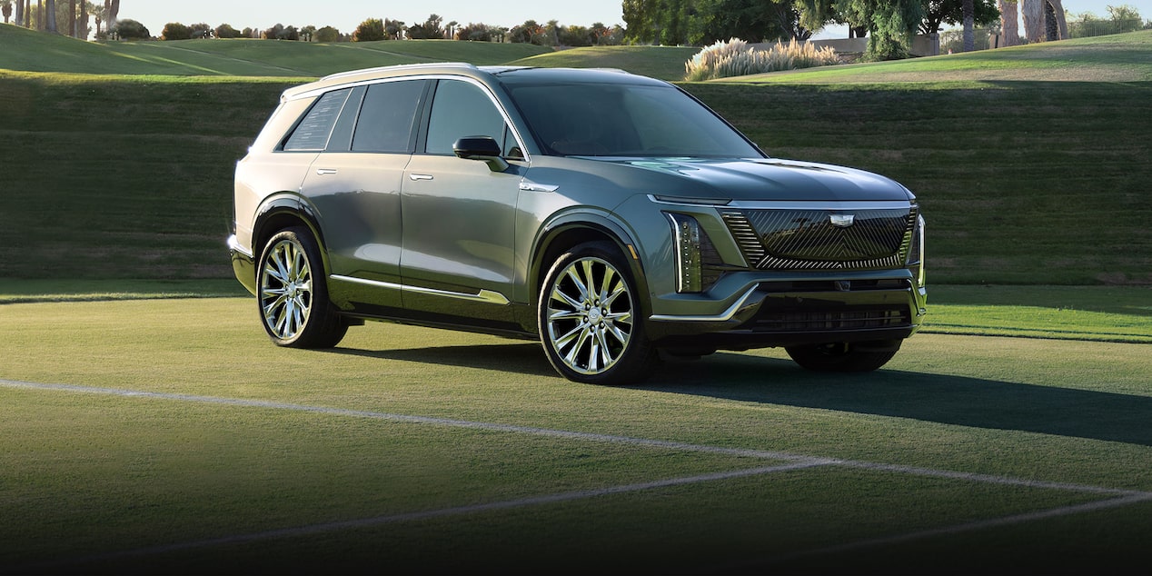 Vista de medio perfil de una Cadillac VISTIQ 2026 estacionada en una cancha de tenis de césped