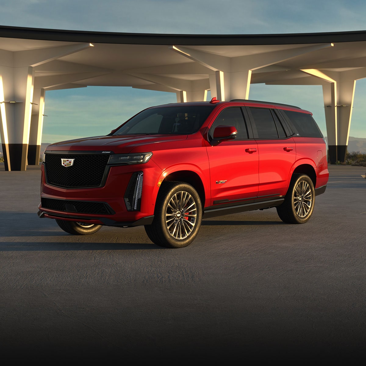 Three-quarter View of a Red 2025 Cadillac Escalade-V Parked Under an Overpass