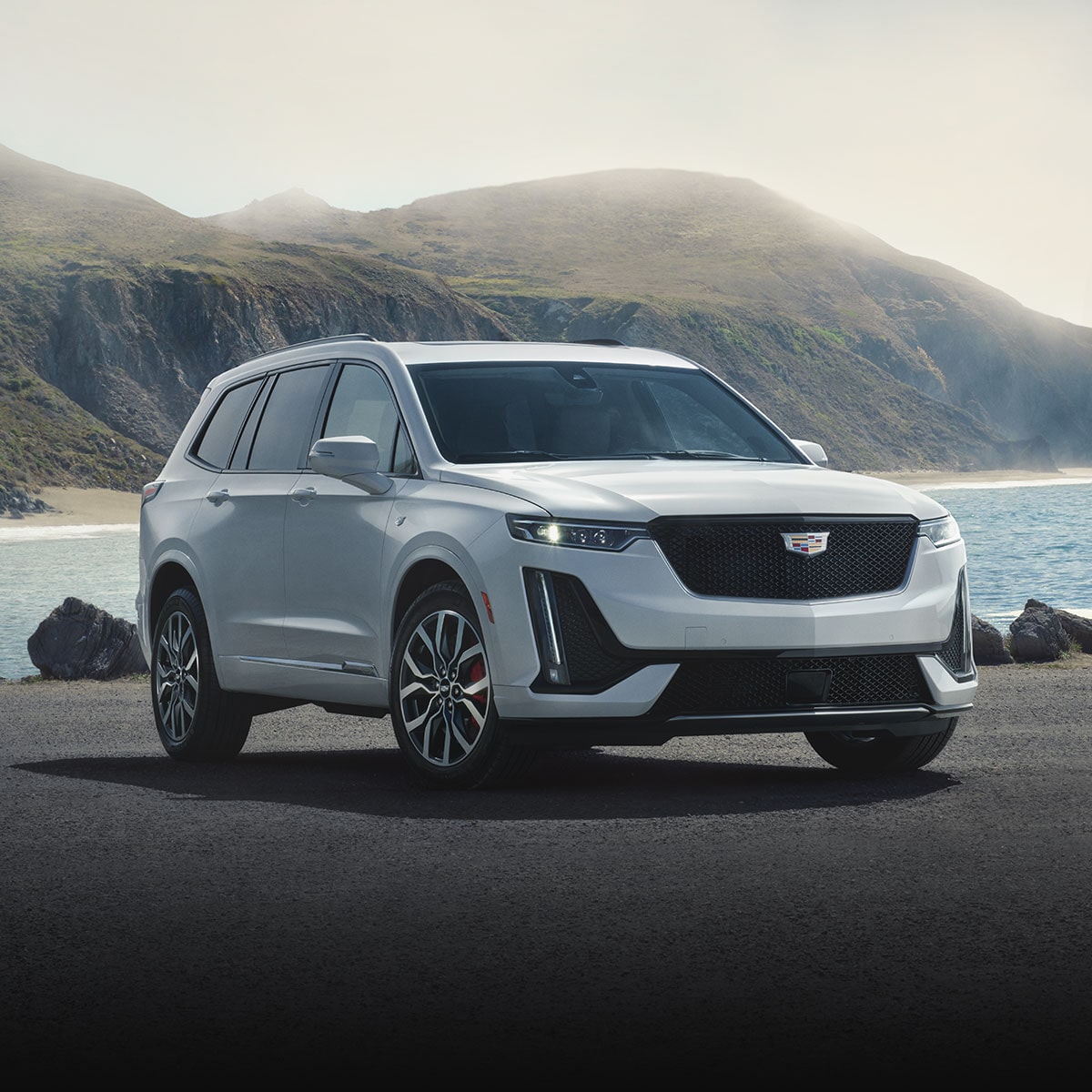 2025 Cadillac XT6 SUV Parked in Front of a Lake and Mountains