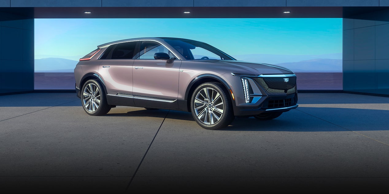 Front View of a Red 2025 Cadillac LYRIQ Cruising Down a Road